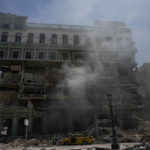 
              Smoke and dust linger at the five-star Hotel Saratoga after a deadly explosion in Old Havana, Cuba, Friday, May 6, 2022. (AP Photo/Ramon Espinosa)
            