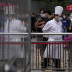 
              A chef and lines up for public COVID-19 testing in the Chaoyang district on Wednesday, May 11, 2022, in Beijing. Shanghai reaffirmed China's strict "zero-COVID" approach to pandemic control Wednesday, a day after the head of the World Health Organization said that was not sustainable and urged China to change strategies. (AP Photo/Andy Wong)
            