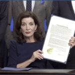 
              In this image taken from video, New York Gov. Kathy Hochul shows an executive e order she signed during a news conference, Wednesday, May 18, 2022, in New York.  New York would require state police to seek court orders to keep guns away from people who might pose a threat to themselves or others under a package of executive orders and gun control bills touted Wednesday by Hochul in the aftermath of a racist attack on a Buffalo supermarket.  (Office of the Governor of New York via AP)
            