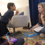 
              Therapist Sarah Sutton, right, listens to an animated Keaton Kotiya, 9, as is brother Ronan Kotiya, 11, sits and listens during a counseling session in Plano, Texas, Friday, April 8, 2022. Caregiving for their father with ALS is a task that children like Ronan and Keaton take seriously and something that their mom hopes will shape them into empathetic, strong young men. But getting there first involves a daily struggle to balance being a kid with living in a very grown-up world. Sutton has seen the boys regularly for a few years. She's been trying to get them to recognize all the emotions hitting them and realize where they are coming from instead of keeping everything bottled up. (AP Photo/LM Otero)
            