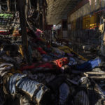 
              Fabrics are spread across one of the shelled sections of the Barabashovo market in Kharkiv, eastern Ukraine, Monday, May 23, 2022. (AP Photo/Bernat Armangue)
            