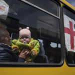 
              A woman with a child from Siversk look though the window of a bus during evacuation near Lyman, Ukraine, Wednesday, May 11, 2022. (AP Photo/Evgeniy Maloletka)
            