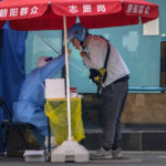 
              A worker in a protective suit swabs a delivery drivers's throat for a COVID-19 test at a coronavirus testing site in Beijing, Wednesday, May 11, 2022. Shanghai reaffirmed China's strict "zero-COVID" approach to pandemic control Wednesday, a day after the head of the World Health Organization said that was not sustainable and urged China to change strategies. (AP Photo/Mark Schiefelbein)
            