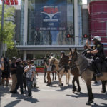 
              Mounted police officers tell protesters to move back across the street from the National Rifle Association annual meeting at the George R. Brown Convention Center in Houston, Friday, May 27, 2022. (AP Photo/Jae C. Hong)
            