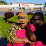 
              People embrace at the scene of Saturday's shooting at a supermarket, in Buffalo, Thursday, May 19, 2022. (AP Photo/Matt Rourke)
            