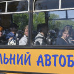 
              People with children sit in a bus during an evacuation of civilians in Kramatorsk, Ukraine, Tuesday, May 3, 2022. The sign reads "School bus". (AP Photo/Andriy Andriyenko)
            