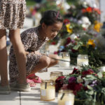 
              A child looks at a memorial site for the victims killed in this week's shooting at Robb Elementary School in Uvalde, Texas, Friday, May 27, 2022. (AP Photo/Dario Lopez-Mills)
            