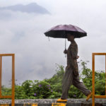 
              A woman holds an umbrella and walks in the rain in Kohima, capital of the northeastern India state of Nagaland, Monday, May 16, 2022. Officials in India say at least eight people have died in floods and mudslides triggered by heavy rains in the country's northeast region. (AP Photo/Yirmiyan Arthur)
            