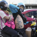 
              A man displays his tattoos from top; Ferdinand Marcos, Ferdinand "Bongbong" Marcos Jr., and Philippine President Rodrigo Duterte as he passes by BBM headquarters in Mandaluyong, Philippines on Tuesday May 10, 2022. Marcos Jr.'s apparent landslide victory in the Philippine presidential election is giving rise to immediate concerns about a further erosion of democracy in the region, and could complicate American efforts to blunt growing Chinese influence and power in the Pacific. (AP Photo/Aaron Favila)
            