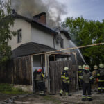 
              Ukrainian firefighters try to extinguish a fire in a house that was hit during a Russian attack with a cluster-type munition in Kharkiv, eastern Ukraine, Monday, May 30, 2022. (AP Photo/Bernat Armangue)
            
