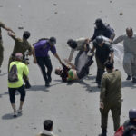 
              Police officers detain a supporter of Pakistan's key opposition as clashes broke out during a protest march toward Islamabad, in Lahore, Pakistan, Wednesday, May 25, 2022. Pakistani authorities blocked off all major roads into the capital Islamabad on Wednesday, after a defiant former Prime Minister Imran Khan said he would march with demonstrators to the city center for a rally he hopes will bring down the government and force early elections. (AP Photo/K.M. Chaudary)
            