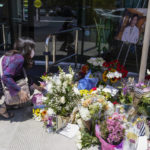 
              Grace Hung, a patient of Dr. John Cheng, places flowers at a memorial honoring him outside his office building on Tuesday, May 17, 2022, in Aliso Viejo, Calif. Cheng, 52, was killed in Sunday's shooting at Geneva Presbyterian Church. (AP Photo/Ashley Landis)
            