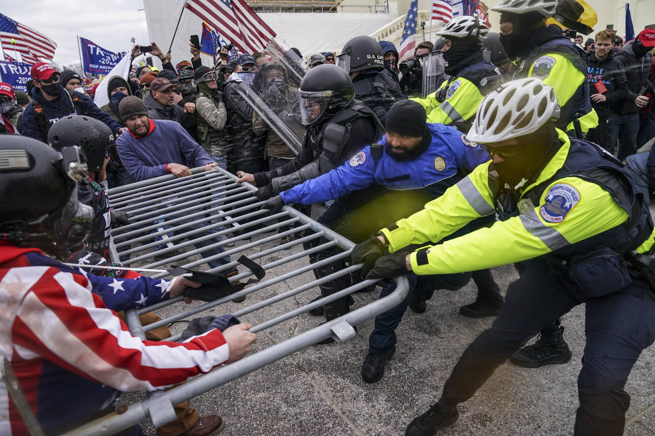 FILE - Rioters try to break through a police barrier at the Capitol in Washington on Jan. 6, 2021. ...