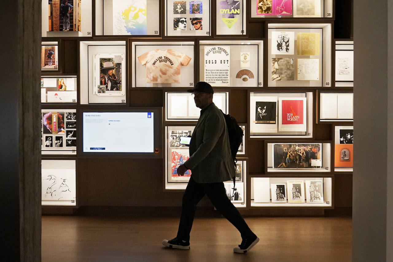 A man walks past a portion of the archive wall at the Bob Dylan Center, Thursday, May 5, 2022, in T...