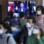 
              People watch a TV screen showing a live broadcast of the inauguration ceremony of newly elected South Korean President Yoon Suk Yeol, at the Seoul Railway Station in Seoul, South Korea, Tuesday, May 10, 2022. South Korea's new president says he'll present "an audacious plan" to improve North Korea's economy if it denuclearizes. Yoon Suk Yeol made the offer during a speech at his inauguration ceremony in Seoul on Tuesday. (AP Photo/Ahn Young-joon)
            