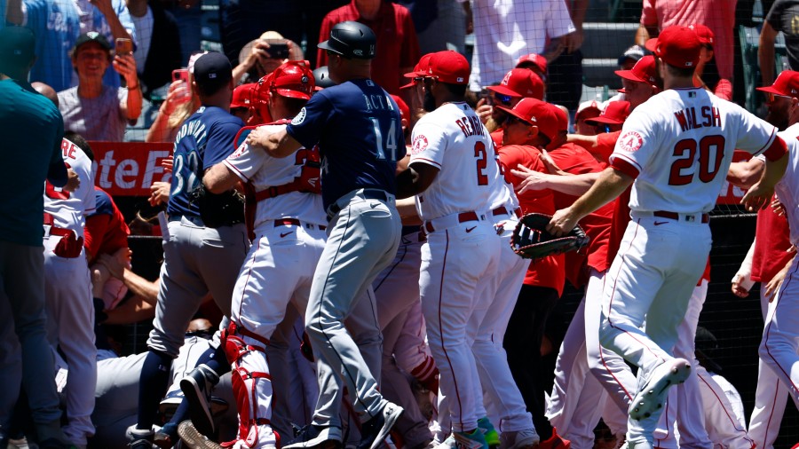 The Seattle Mariners and the Los Angeles Angels clear the benches after Jesse Winker #27 of the Sea...