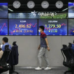 
              A currency trader passes by screens showing the Korea Composite Stock Price Index (KOSPI), center left, and the exchange rate of South Korean won against the U.S. dollar, center right, at the foreign exchange dealing room of the KEB Hana Bank headquarters in Seoul, South Korea, Thursday, June 16, 2022. Asian shares advanced Thursday after the Federal Reserve raised its key interest rate by three-quarters of a point and signaled more rate hikes were coming to fight inflation. (AP Photo/Ahn Young-joon)
            