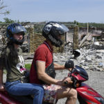
              People ride a bike past a building damaged by an overnight missile strike in Sloviansk, Ukraine, Wednesday, June 1, 2022. (AP Photo/Andriy Andriyenko)
            