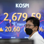 
              A currency trader walks by the screens showing the Korea Composite Stock Price Index (KOSPI) at a foreign exchange dealing room in Seoul, South Korea, Friday, June 3, 2022. Asian shares rose Friday amid mixed signs for investors such as rising energy prices and COVID-19 restrictions easing in China. (AP Photo/Lee Jin-man)
            