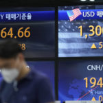 
              A currency trader walks near the screens showing the foreign exchange rates at a foreign exchange dealing room in Seoul, South Korea, Friday, June 24, 2022. Shares were higher in Asia on Friday, tracking gains on Wall Street, where the market is headed for its first weekly gain after three weeks of punishing losses. (AP Photo/Lee Jin-man)
            