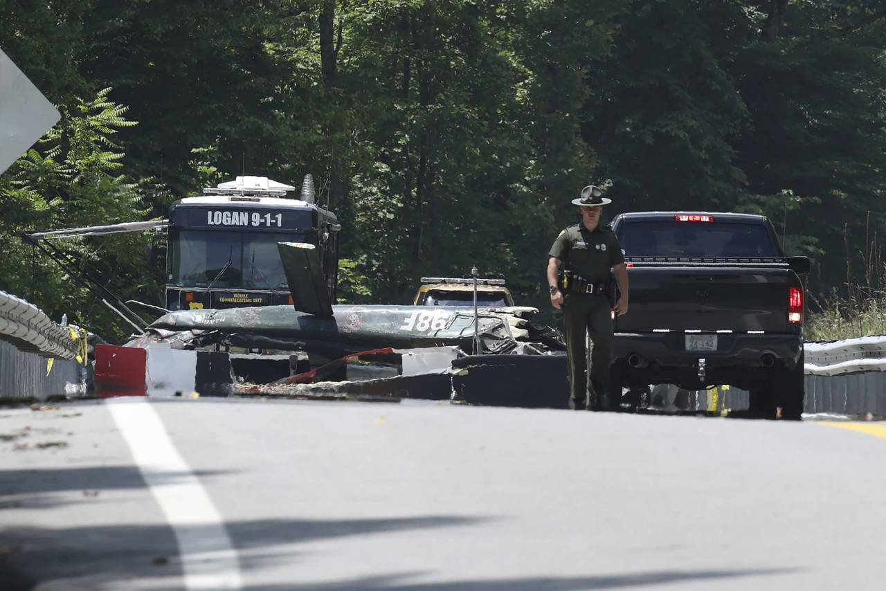 Emergency personnel look over the sight of a  helicopter that crashed in Blair, W.Va., on Thursday,...