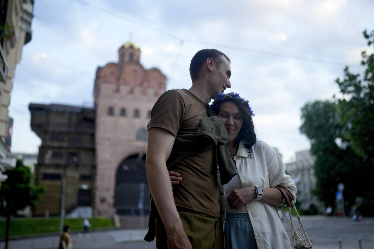 Stand-up comics Serhiy Lipko and Anastasia Zukhvala embrace during an interview with The Associated...
