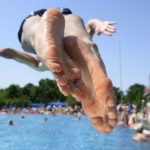 
              A young man jumps into the water at the Georg Arnhold pool in summer temperatures above 30 degrees Celsius, in Dresden, Germany, Saturday, June 18, 2022. (Robert Michael/dpa via AP)
            