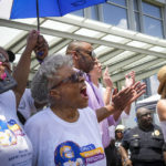 
              Opal Lee, center, cheers as the Juneteenth flag is raised at Fort Worth City Hall at the conclusion of the 2022 Opal's Walk for Freedom on Saturday, June 18, 2022, in Fort Worth. Lee, often referred to as the "Grandmother of Juneteenth" led her annual two-and-a-half-mile walk, representing the number of years after the Emancipation Proclamation before enslaved people in Texas learned they were free. Behind Lee are U.S. Rep. Marc Veasey, Democratic candidate for Governor Beto O"Rourke and Fort Worth Mayor Mattie Parker. (Smiley N. Pool/The Dallas Morning News via AP)
            