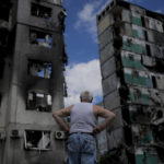 
              A man stands looking at a building destroyed during attacks, in Borodyanka, on the outskirts of Kyiv, Ukraine, Saturday, June 4, 2022. (AP Photo/Natacha Pisarenko)
            
