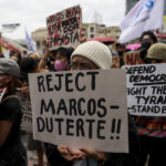 
              Activists hold placards against the inauguration ceremony of President-elect Ferdinand Marcos Jr. during a protest in Manila, Philippines on Thursday, June 30, 2022. Ferdinand Marcos Jr., the namesake son of an ousted dictator, was sworn in as Philippine president Thursday in one of history's greatest political comebacks but which opponents say was pulled off by whitewashing his family's image. (AP Photo/Basilio Sepe)
            