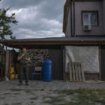 
              A man smokes his cigarette in front of a home damaged by Russian strikes, in Yahidne village, northern Chernihiv region, Ukraine, Wednesday, June 29, 2022. A few months after Russian troops retreated from Yahidne, the village has gradually returned to life. People are repairing their homes, and a strong wind occasionally picks up the bitter smell of ashes. (AP Photo/Nariman El-Mofty)
            