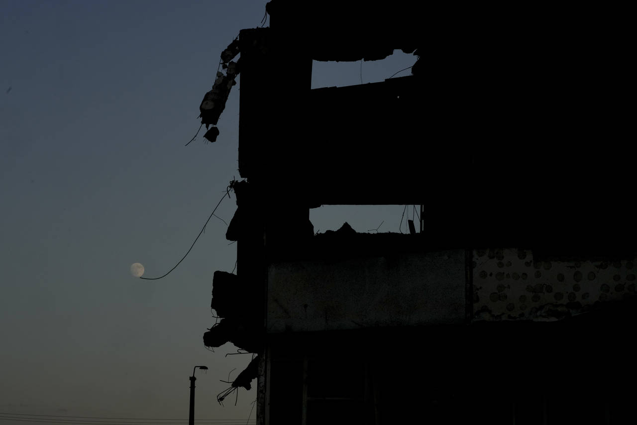 The moon is seen near a building destroyed by attacks in Borodyanka, on the outskirts of Kyiv, Ukra...