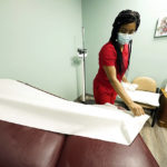 
              A medical assistant pulls down fresh covering on an examination table at Sisters in Birth, a Jackson, Miss., clinic that serves pregnant women, Dec. 17, 2021. (AP Photo/Rogelio V. Solis)
            