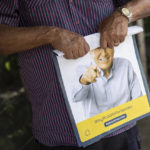 
              A supporter rolls up a poster featuring presidential candidate Rodolfo Hernandez a day ahead of the country's presidential run-off, in Bucaramanga, Colombia, Saturday, June 18, 2022.  Polls show rival Gustavo Petro and Hernandez, both former mayors, practically tied since advancing to the June 19th runoff following the first-round election in which they beat four other candidates. (AP Photo/Ivan Valencia)
            