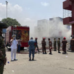
              Military personnel stand guard at the BM Inland Container Depot, where a fire broke out around midnight Saturday in Chittagong, about 210 kilometers (130 miles) southeast of, Dhaka, Bangladesh, Monday, June 6, 2022. Dozens of people were killed and more than 100 others were injured after the inferno broke out following explosions in a container full of chemicals. (AP Photo/ Al-emrun Garjon)
            
