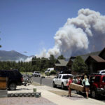 
              People evacuate their home as the Pipeline Fire burns in the mountains above Flagstaff, Ariz., Sunday, June 12, 2022. The fire has forced the evacuation of several hundred homes. (Jake Bacon/Arizona Daily Sun via AP)
            