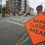 
              A sign is shown near ongoing work on a project to replace water main pipes, Wednesday, June 15, 2022, in downtown Tacoma, Wash. Inflation is taking a toll on infrastructure projects across the U.S., driving up costs so much that state and local officials are postponing projects, scaling back others and reprioritizing their needs. (AP Photo/Ted S. Warren)
            
