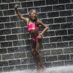 
              Larese Jones, 9, of East Garfield Park, plays with other children in her mother's day care in the Crown Fountain on Michigan Avenue, Tuesday afternoon, June 14, 2022, in Chicago. Much of the Midwest and a swath of the South braced for a potentially dangerous and deadly heat wave on Tuesday, with temperatures that could reach record highs in some places and combine with humidity to make it feel like it’s 100 degrees or hotter in spots. (Ashlee Rezin/Chicago Sun-Times via AP)
            