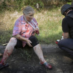 
              EDS NOTE: GRAPHIC CONTENT - Police officers give the first aid to an elderly woman wounded by the Russian shelling in city center in Slavyansk, Donetsk region, Ukraine, Monday, June 27, 2022. (AP Photo/Efrem Lukatsky)
            