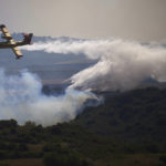 
              A firefight plane drops a fire retardant on a burning area of San Martin de Unx in northern Spain, Sunday, June 19, 2022. Firefighters in Spain are struggling to contain wildfires in several parts of the country suffering an unusual heat wave for this time of the year. (AP Photo/Miguel Oses)
            