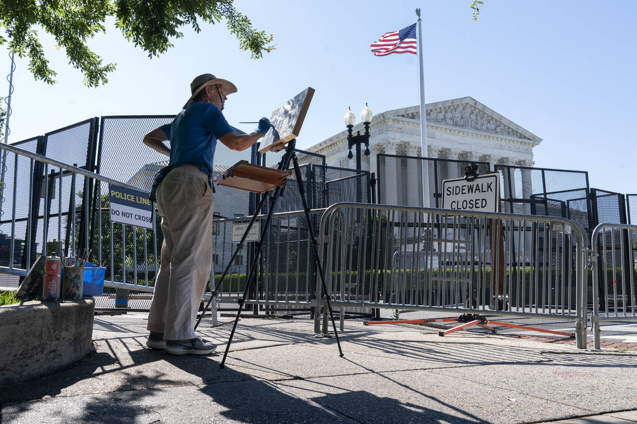 Artist Elaine Wilson works on a painting of the Supreme Court, Wednesday, June 29, 2022, in Washing...