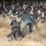 
              A migrant is detained by police officers on Spanish soil after crossing the fences separating the Spanish enclave of Melilla from Morocco in Melilla, Spain, Friday, June 24, 2022. Dozens of migrants stormed the border crossing between Morocco and the Spanish enclave city of Melilla on Friday in what is the first such incursion since Spain and Morocco mended diplomatic relations last month. (AP Photo/Javier Bernardo)
            