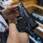 
              A customer checks out a hand gun that is for sale and on display at SP firearms on Thursday, June 23, 2022, in Hempstead, New York. (AP Photo/Brittainy Newman)
            