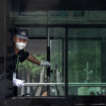 
              A security guard wearing a face mask looks out from the window of a public bus in Beijing, Friday, June 17, 2022. (AP Photo/Mark Schiefelbein)
            