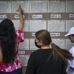 
              Voters look for their voting post during a presidential runoff in Bucaramanga, Colombia, Sunday, June 19, 2022. (AP Photo/Ivan Valencia)
            