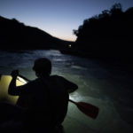 
              FILE - A river rafting guide paddles at dusk on the Vjosa River, Albania, June 29, 2019. Officials on Monday, June 13, 2022, declared the Vjosa River and its tributaries a future national park, a move aimed at preserving what they called one of the last wild rivers in Europe. The Albanian Ministry of Tourism and Environment signed an agreement with the California-based Patagonia environmental organization to draft an “integrated and sustainable plan" for the new park. (AP Photo/Felipe Dana, File)
            