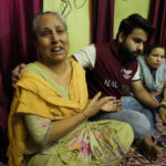 
              Neena kumar, 55, left, wails seated next to her son Karan Chib after they left Kashmir valley, in Jagti Migrant camp outskirts of Jammu, India, Friday, June.10, 2022. Chib is the only bread earner of the family. Kashmir has witnessed a spate of targeted killings in recent months. Several Hindus, including immigrant workers from Indian states, have been killed. The recent killings have heightened their fears. (AP Photo/Channi Anand)
            