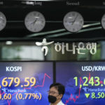 
              A currency trader walks by the screens showing the Korea Composite Stock Price Index (KOSPI), left, and the foreign exchange rate between U.S. dollar and South Korean won at a foreign exchange dealing room in Seoul, South Korea, Friday, June 3, 2022. Asian shares rose Friday amid mixed signs for investors such as rising energy prices and COVID-19 restrictions easing in China. (AP Photo/Lee Jin-man)
            