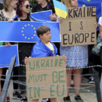 
              Protestors in support of Ukraine stand with signs and EU flags during a demonstration outside of an EU summit in Brussels, Thursday, June 23, 2022. European Union leaders are expected to approve Thursday a proposal to grant Ukraine a EU candidate status, a first step on the long toward membership. (AP Photo/Olivier Matthys)
            