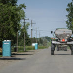 
              Portable toilets brought in for residents after a sewer line broke during the severe flooding sit outside homes as a tractor passes through Edgar, Mont. Friday, June 17, 2022. (AP Photo/David Goldman)
            